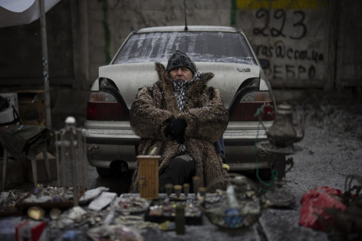 A vendor sits at a flea market in Kyiv, Ukraine, Saturday, Feb. 4, 2023. (AP Photo/Daniel Cole)