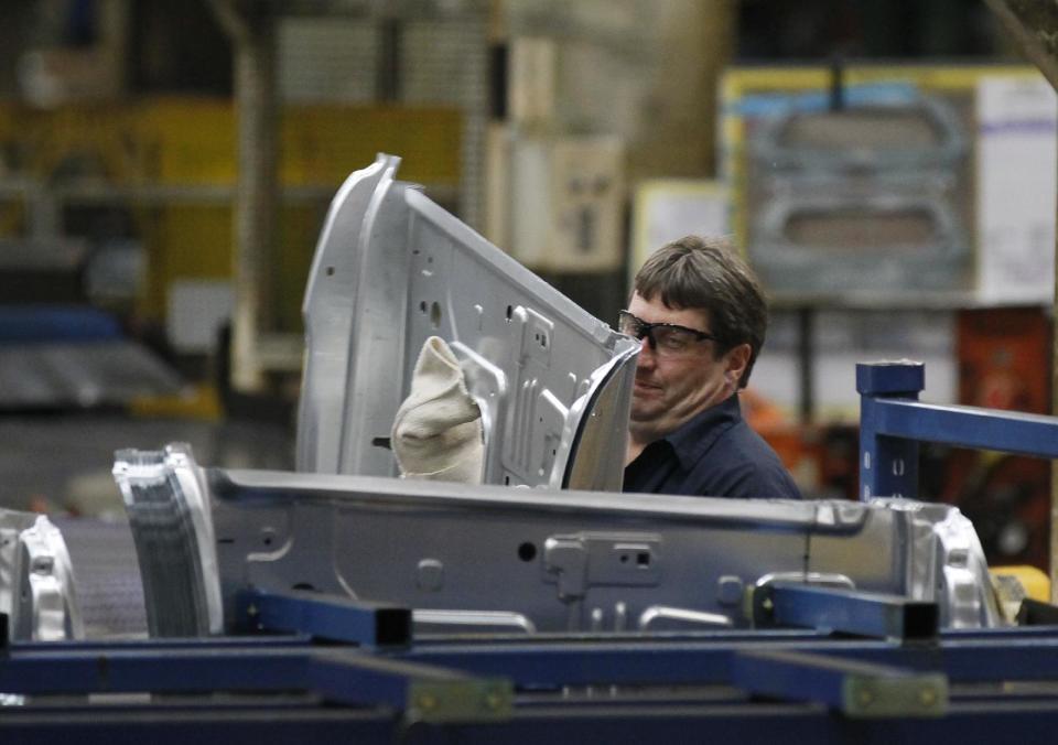 In this April 4, 2012, photo, an auto worker at the Ford Stamping Plant in Chicago Heights, Ill. Plummeting sales in Europe, and no hope for a quick fix in the troubled region, hurt Ford's second-quarter profit and forced the company to lower its full-year earnings forecast Wednesday, July 25, 2012. (AP Photo/Charles Rex Arbogast)