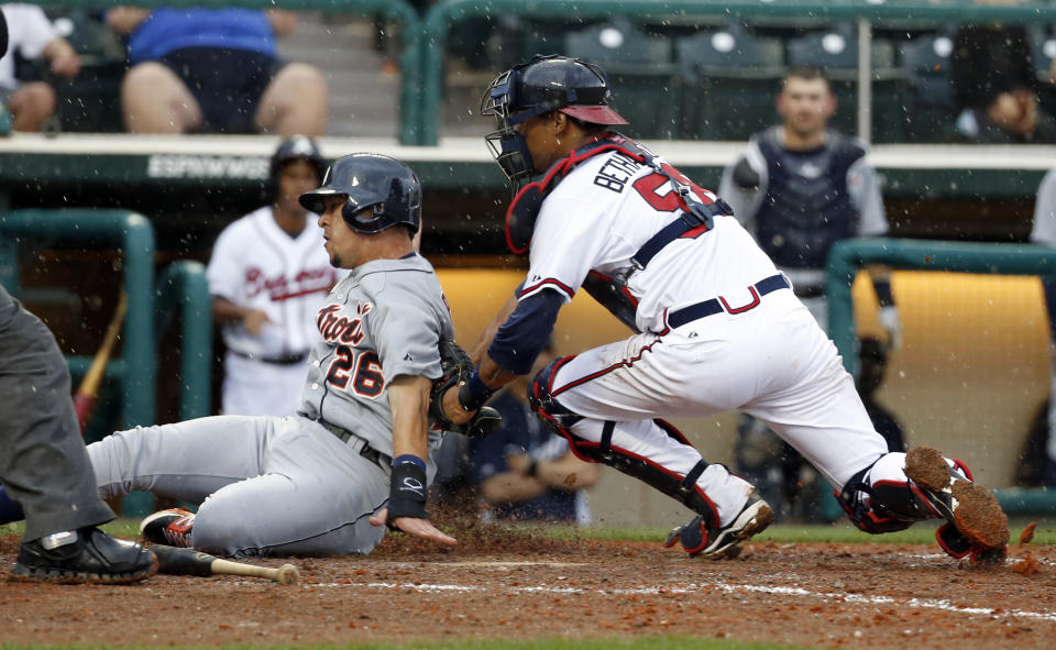 Atlanta Braves catcher Christian Bethancourt tags Detroit Tigers' Hernan Perez for the out at home in the ninth inning of a spring training baseball game, Wednesday, Feb. 26, 2014, in Kissimmee, Fla. The Tigers won 6-5. The game was stopped because of rain with two outs in the bottom of the ninth, and the Tigers were awarded the win. (AP Photo/Alex Brandon)