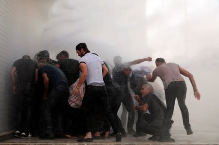 Police use a water cannon to disperse demonstrators during a protest against the replacement of Kurdish mayors with state officials in three cities, in Diyarbakir