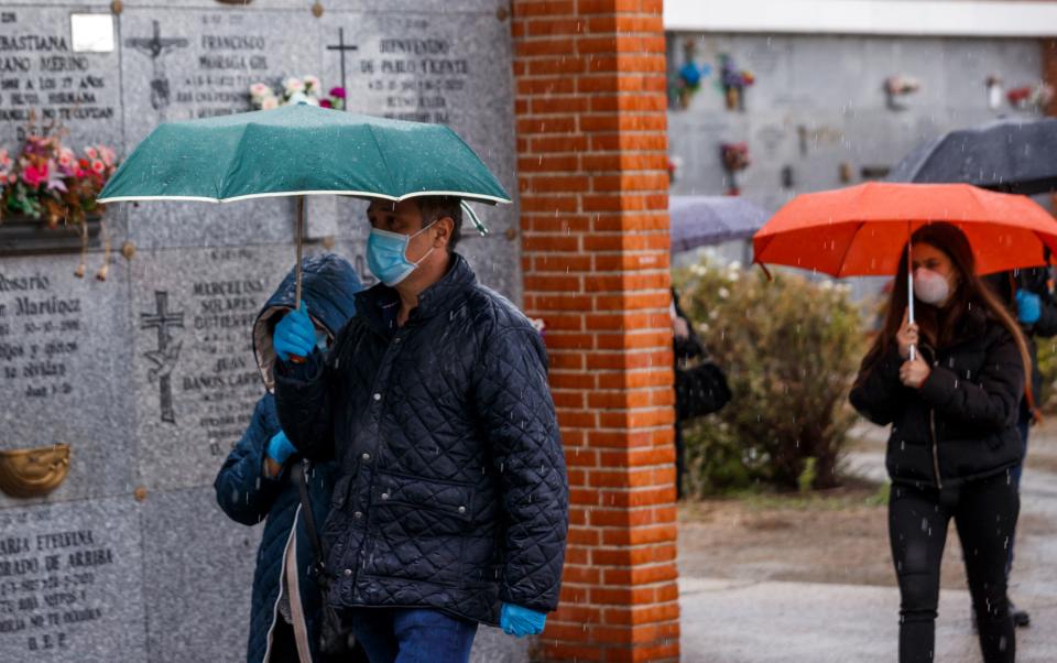 People wearing face masks arrive at the South Municipal cemetery in Madrid, on March 23, 2020, to attend the burial of a man who died of the new coronavirus. - The coronavirus death toll in Spain surged to 2,182 after 462 people died within 24 hours, the health ministry said. The death rate showed a 27-percent increase on the figures released a day earlier, with the number of confirmed cases of COVID-19 rising to 33,089 in Spain, one of the worst-hit countries in the world after China and Italy. (Photo by BALDESCA SAMPER / AFP) (Photo by BALDESCA SAMPER/AFP via Getty Images)