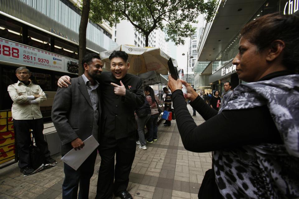 Howard poses with a visitor as he appears as a Kim Jong-un lookalike on a street at Hong Kong's Tsim Sha Tsui shopping district