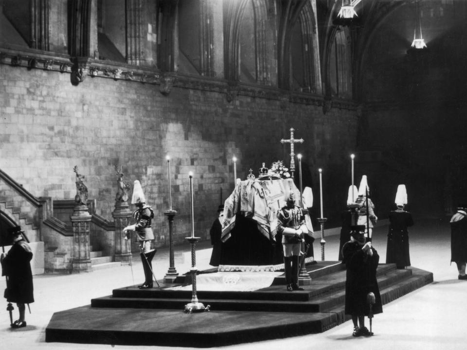 Guards standing around King George V's coffin as it lies-in-state.