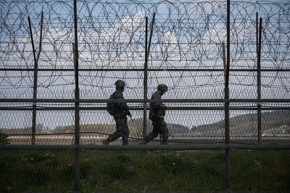 South Korean soldiers patrol along a barbed wire fence Demilitarised Zone (DMZ) separating North and South Korea, on the South Korean island of Ganghwa.