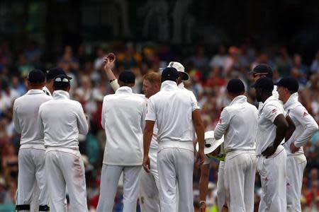 England's Ben Stokes (C) is surrounded by his team mates as he shows the ball to the crowd after taking his fifth wicket for the innings during the first day of the fifth Ashes cricket test against Australia at the Sydney cricket ground January 3, 2014. REUTERS/David Gray