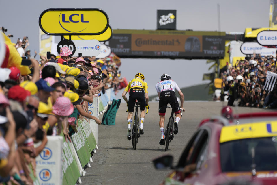 Tadej Pogacar (blanco) y el líder general Jonas Vingegaard se acercan a la meta de la 17ma etapa del Tour de Francia en Peyragudes. (AP Foto/Thibault Camus)