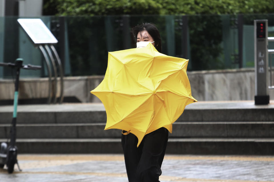 A woman holds an umbrella against the strong wind and rain caused by Typhoon Bavi in Seoul, South Korea, Thursday, Aug. 27, 2020. Typhoon Bavi that grazed South Korea and caused some damage has made landfall in North Korea early Thursday. South Korean authorities said there were no immediate reports of casualties, and North Korea has not reported any damages. (AP Photo/Ahn Young-joon)