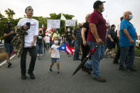 People march along Las Americas Highway to protest the LUMA Energy company in San Juan, Puerto Rico, Friday, Oct. 15, 2021. Ever since LUMA began providing service over the summer, hundreds of thousands of Puerto Ricans have had to deal with widespread blackouts for extended periods of time, voltage fluctuations and bad customer service along with an increase in pricing. (AP Photo/Carlos Giusti)