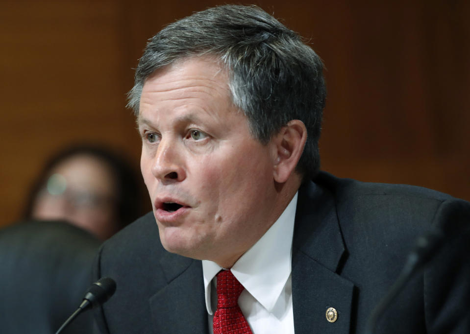 FILE - In this May 10, 2018 file photo, Sen. Steve Daines, R-Mont., asks a question during a Senate Appropriations subcommittee hearing on Capitol Hill in Washington. Gov. Steve Bullock, D-Mont., was the lame-duck governor of solidly red Montana, fresh off a failed Democratic presidential bid, when he pivoted and announced he’d challenge Republican Sen. Steve Daines for his seat. But days after he announced his candidacy last month, the coronavirus claimed its first cases in Montana. That shifted the spotlight onto Bullock as he leads the state’s pandemic response, leaving Daines in the unusual position of a sitting senator competing for attention. (AP Photo/Jacquelyn Martin, File)