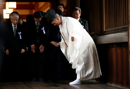 A group of lawmakers including Japan's ruling Liberal Democratic Party (LDP) lawmaker Hidehisa Otsuji (L) bow with a Shinto priest as they visit Yasukuni Shrine in Tokyo, Japan April 21, 2017. REUTERS/Toru Hanai