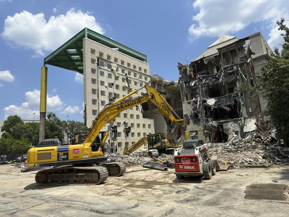 Workers knock down a former Coca-Cola Co. museum in downtown Atlanta on Friday, May 14, 2024. The World of Coca-Cola museum moved to a new site in downtown Atlanta in 2006 and Georgia state government is demolishing the vacant structure to turn it into a parking lot. (AP Photo/Jeff Amy)