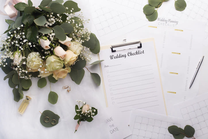 A wedding checklist next to a bouquet.