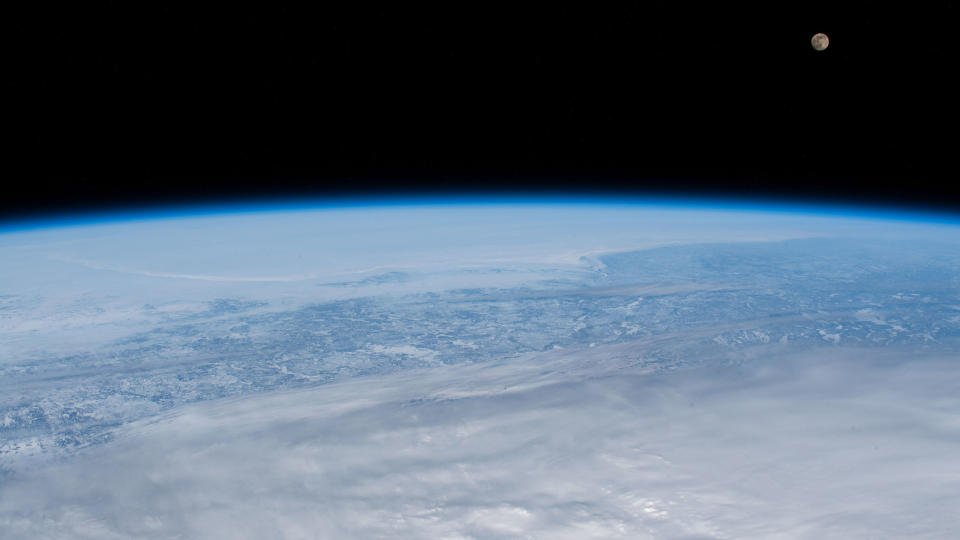 The nearly-full Pink Moon rises over a cloud-covered Earth in this photo taken by an astronaut at the International Space Station on April 6, 2020.