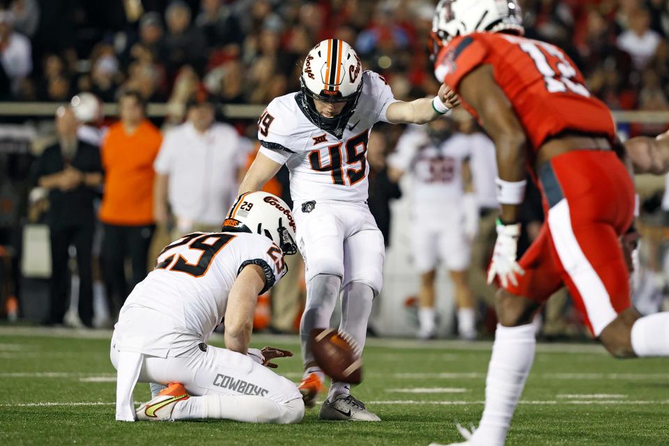 Oklahoma State's Tanner Brown (49) kicks a field goal during the first half of an NCAA college football game against Texas Tech, Saturday, Nov. 20, 2021, in Lubbock, Texas. (AP Photo/Brad Tollefson)