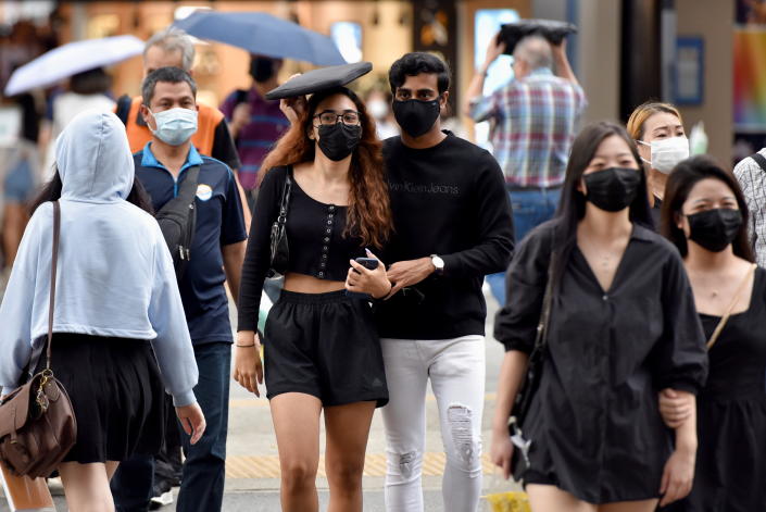 People cross a road, amidst the coronavirus disease (COVID-19) pandemic, in Singapore November 3, 2021. REUTERS/Caroline Chia