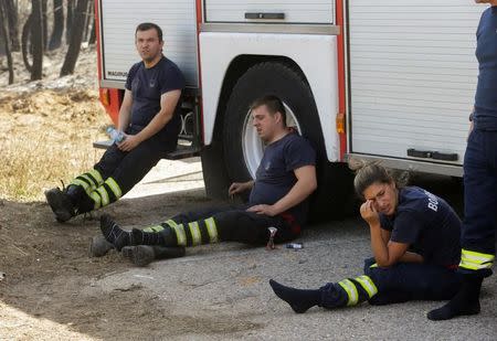 Firefighters take a break from fighting a forest fire in Alto da Louriceira, Portugal, June 21, 2017. REUTERS/Miguel Vidal