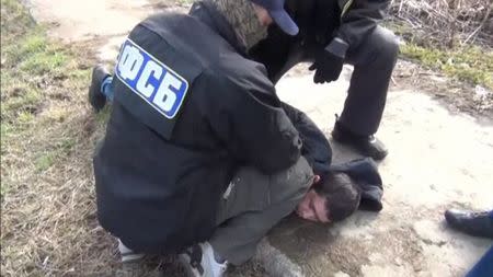 A still image taken from a video footage and released by Russia's Federal Security Service (FSB) on April 17, 2017, shows a suspect over the recent bombing of a metro train in St Petersburg, while being detained by FSB officers in Moscow region, Russia. Russia's Federal Security Service/RBC/Handout via REUTERS TV