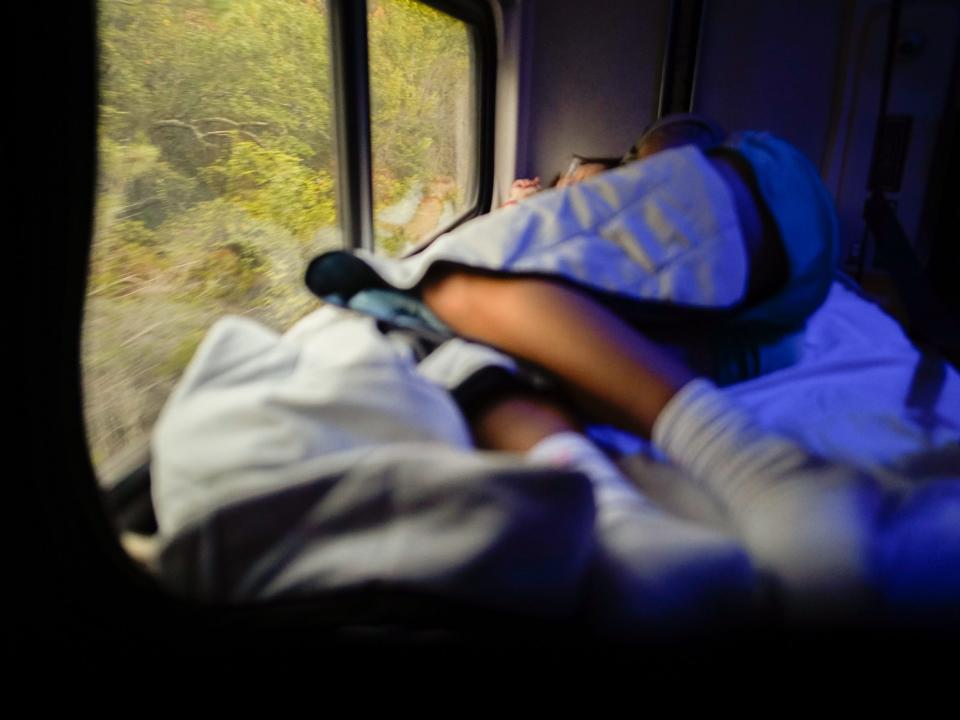 The author lays in the train bed looking out the window on the left side