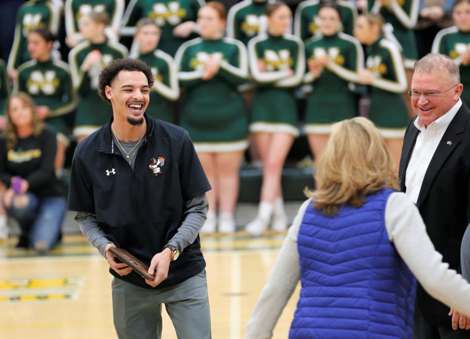 Northeastern graduate Tyler Smith shares a laugh with loved ones and former coaches during his jersey retirement ceremony Feb. 17, 2023.