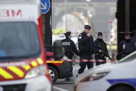 French police and emergency services are seen at the site near the Louvre Pyramid in Paris, France, February 3, 2017 after a French soldier shot and wounded a man armed with a machete and carrying two bags on his back as he tried to enter the Paris Louvre museum. REUTERS/Christian Hartmann