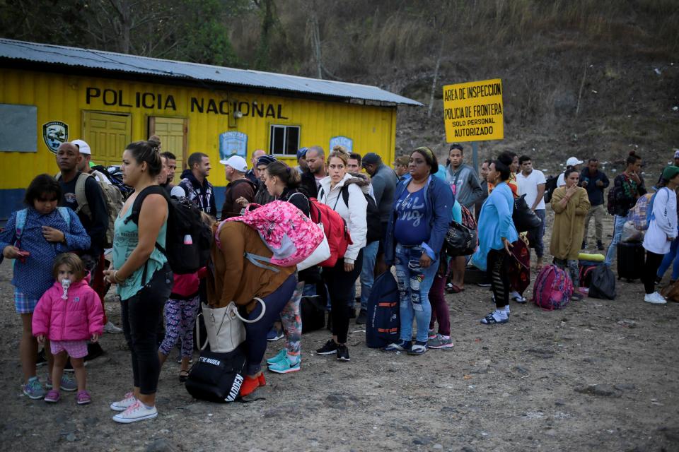 AME9777. AGUA CALIENTE (HONDURAS), 12/04/2019.- Migrantes cubanos hacen fila este viernes ante la Aduana de Agua Caliente (Honduras), fronterizo con Guatemala. En este punto fronterizo se encuentra una caravana migrante convocada por redes sociales y que salió el martes de San Pedro Sula, en el norte hondureño. EFE/ Gustavo Amador