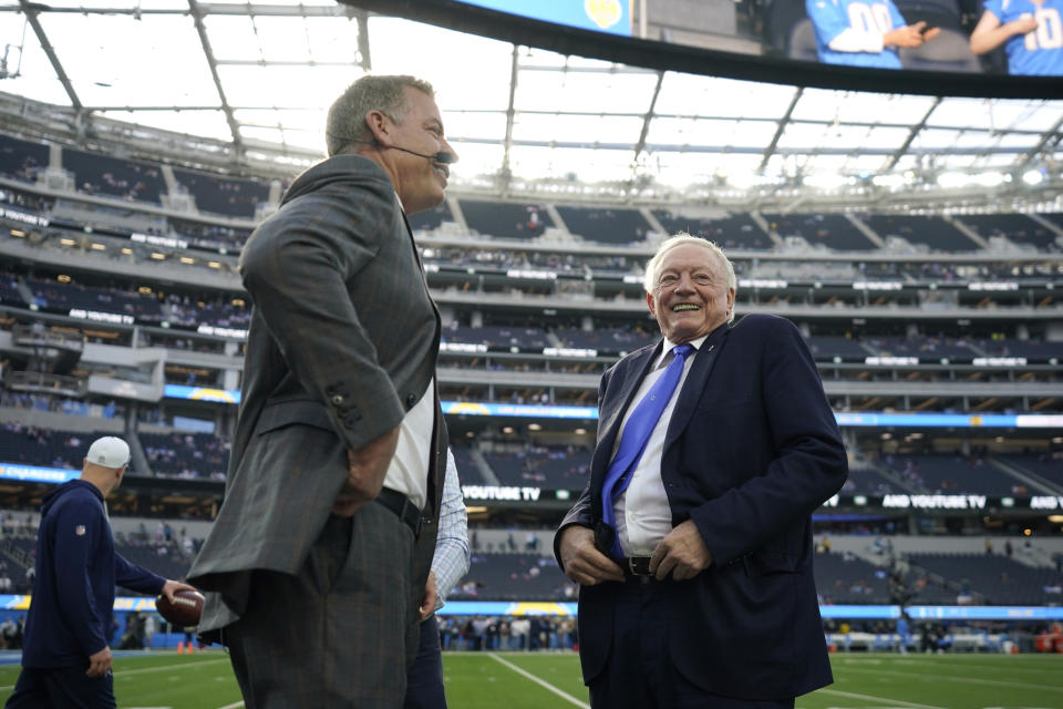 Former Dallas Cowboys quarterback Troy Aikman, left, and Cowboys owner Jerry Jones speak before an NFL football game against the Los Angeles Chargers, Monday, Oct. 16, 2023, in Inglewood, Calif. (AP Photo/Ashley Landis)