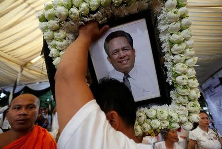 A man holds portrait of Kem Ley, an anti-government figure and the head of a grassroots advocacy group, "Khmer for Khmer", shot dead on July 10, as they attend a funeral procession to carry his body to his hometown, in Phnom Penh July 24, 2016. REUTERS/Samrang Pring