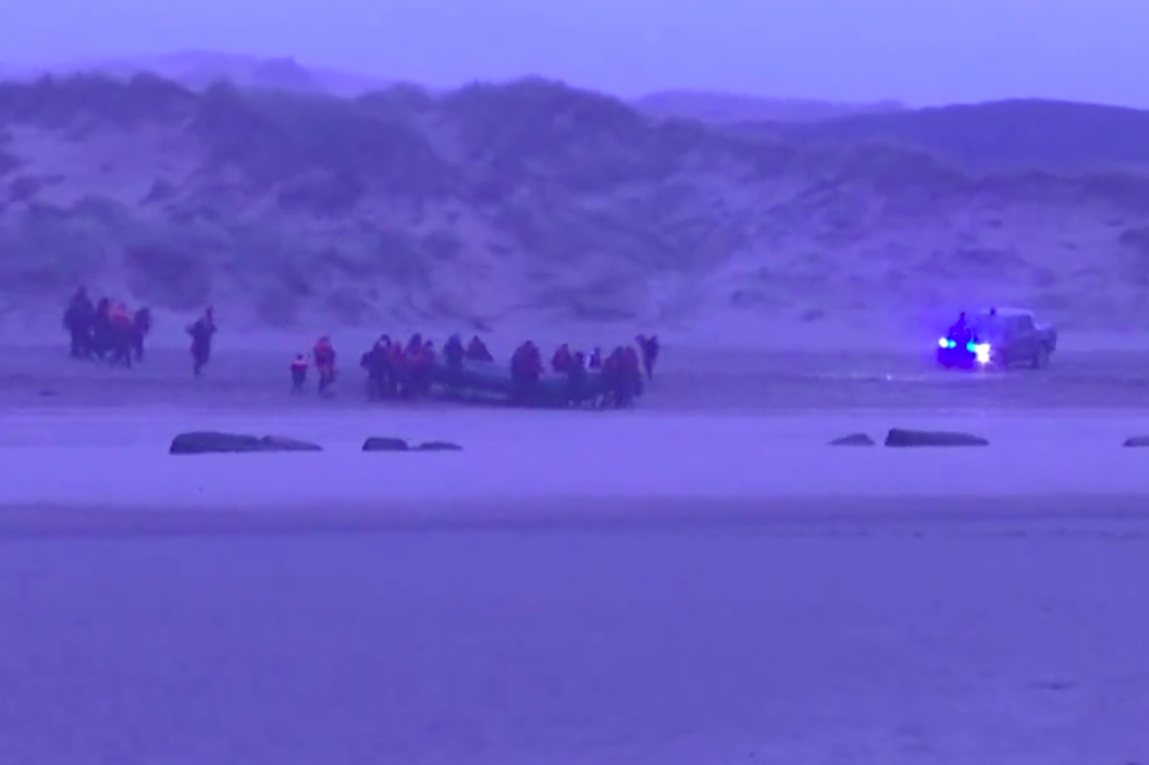 A police car flashes at a group of over 40 migrants heading towards Britain on a dinghy from the beach near Wimereux in northern France. (Reuters)