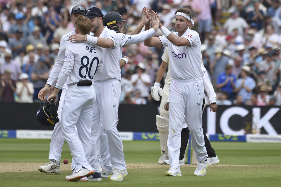 England's Stuart Broad, right celebrates with teammates after taking the wicket of Australia's Scott Boland caught by England's Ollie Pope during day three of the first Ashes Test cricket match between England and Australia at Edgbaston, Birmingham, England, Sunday, June 18, 2023. (AP Photo/Rui Vieira)