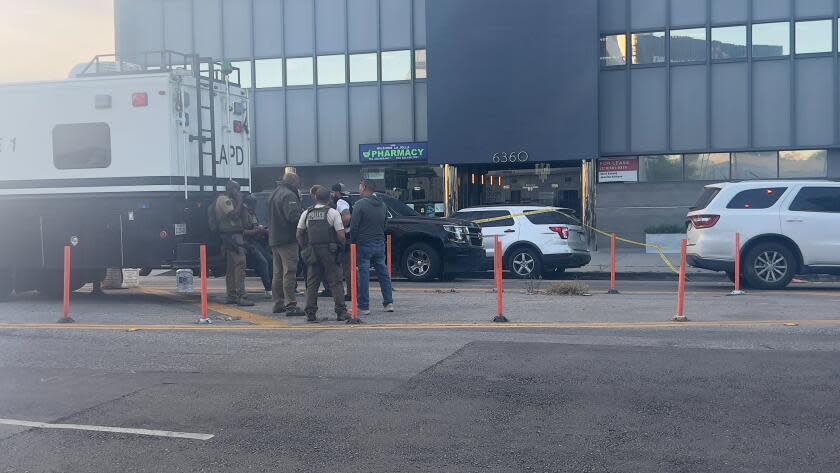 Investigators look over the scene where at least one person was shot and another was bitten by a dog during an incident in Mid-City on Monday that appeared to involve U.S. Marshals, according to police radio calls.