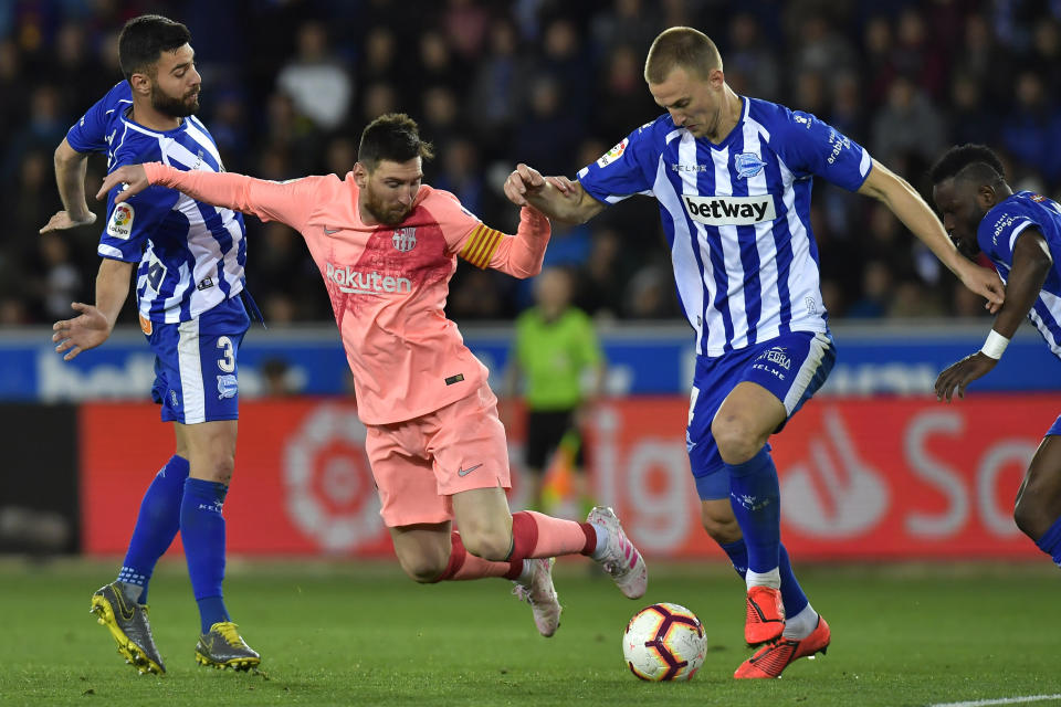 Barcelona forward Lionel Messi fights for the ball against Deportivo Alaves Rodrigo Ely during a Spanish La Liga soccer match between Deportivo Alaves and FC Barcelona at the Medizorrosa stadium in Vitoria, Spain, Tuesday, April 23, 2019. (AP Photo/Alvaro Barrientos)