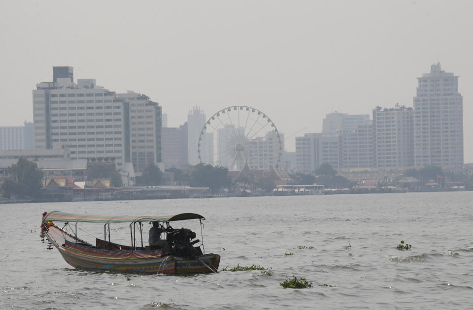 A boat crosses the Chao Phraya river with the cityscape covered smog in Bangkok, Thailand, Monday, Jan. 14, 2019. Unusually high levels of smog worsened by weather patterns are raising alarm across Asia. (AP Photo/Sakchai Lalit)