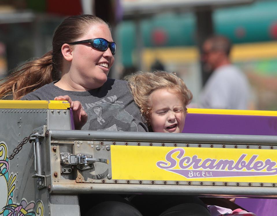 Five-year-old Ady Pettigrew is pushed up against her mother Katie Pettigrew while riding the Scrambler at the Stark County Fair on Sept. 4 , 2021.