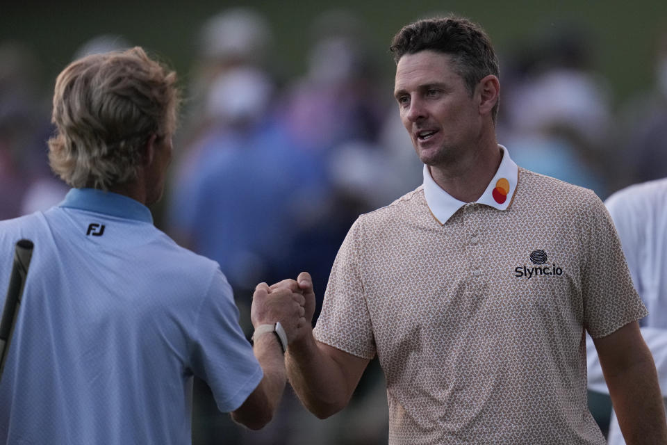 Justin Rose, of England, bumps fists with Will Zalatoris, left, on the 18th hole during the third round of the Masters golf tournament on Saturday, April 10, 2021, in Augusta, Ga. (AP Photo/Gregory Bull)