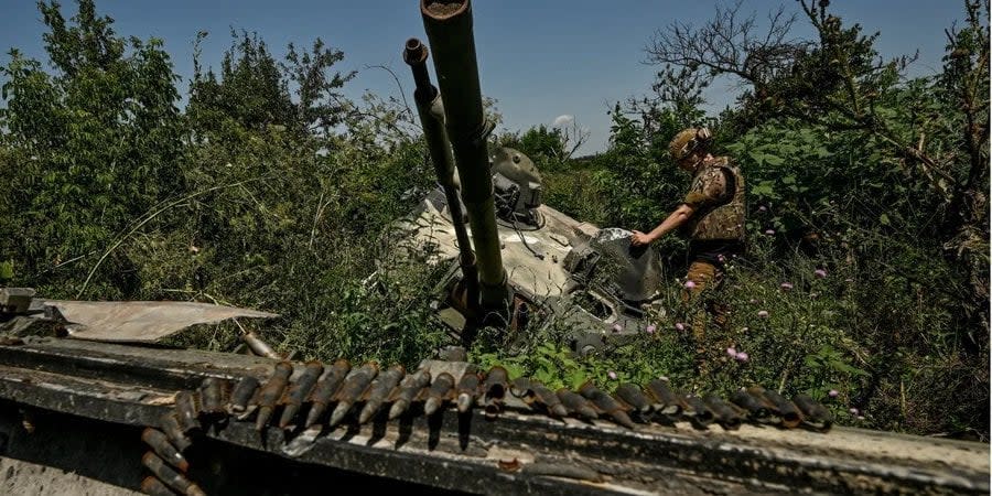 A Ukrainian military officer inspects a Russian tank on liberated territory in Zaporizhzhya Oblast