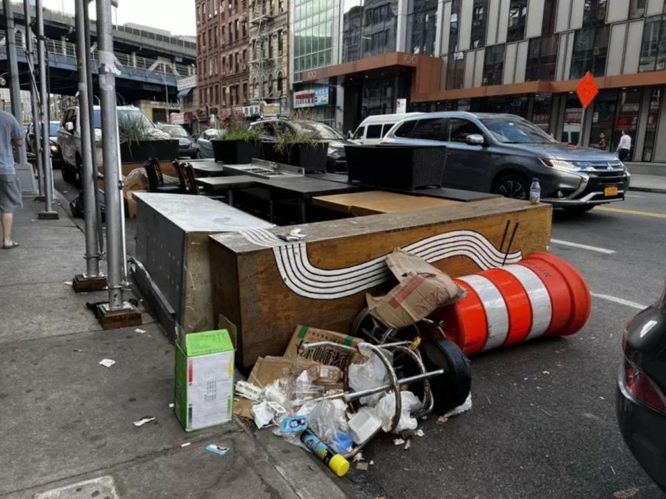 華埠街頭被遺棄的餐棚，變成「臨時垃圾站」，引居民抱怨。(記者張晨／攝影)