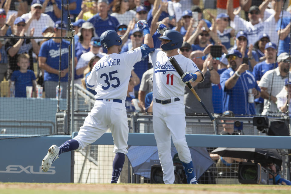 Los Angeles Dodgers' Cody Bellinger, left, gets a high forearm slam from A. J. Pollock after hitting a grand slam against the Colorado Rockies during the fifth inning of a baseball game in Los Angeles, Sunday, Sept. 22, 2019. (AP Photo/Sam Gangwer )