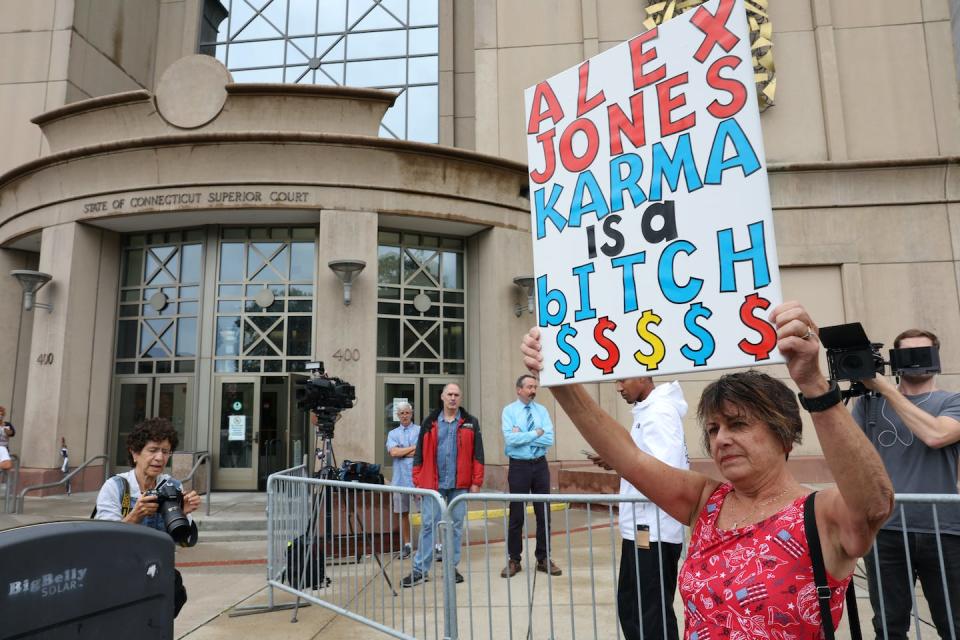 A protester stands outside the Superior Court in Waterbury, Conn., during the start of the trial against Alex Jones. Spencer Platt/ Getty Images