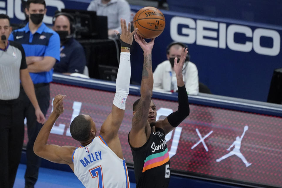 San Antonio Spurs guard Dejounte Murray (5) shoots as Oklahoma City Thunder forward Darius Bazley (7) defends during the first half of an NBA basketball game Wednesday, Feb. 24, 2021, in Oklahoma City. (AP Photo/Sue Ogrocki)