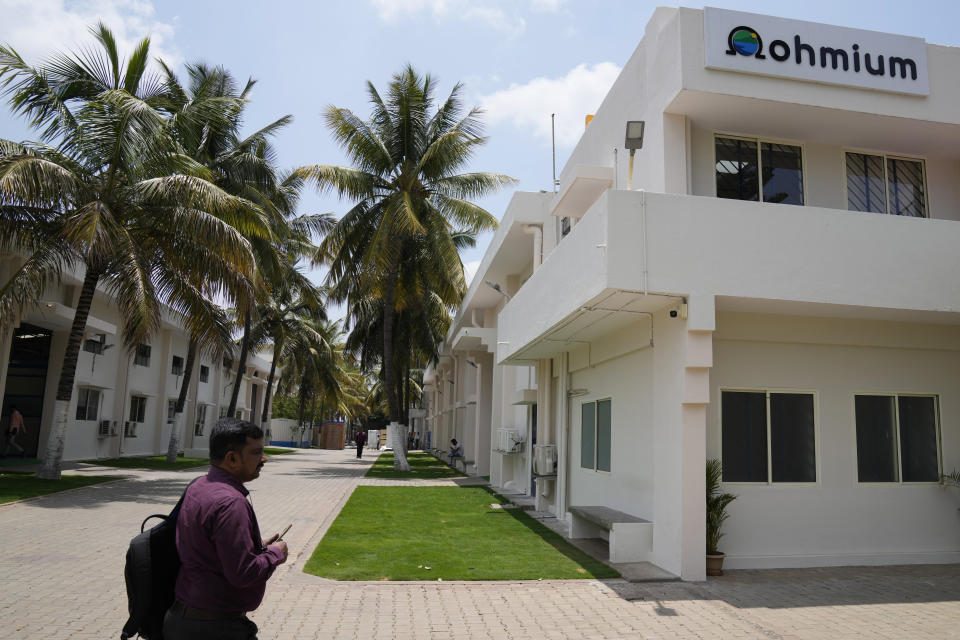 An employee walks past a building at the Ohmium manufacturing facility in Chikkaballapur, outside Bengaluru, India, Tuesday, April 25, 2023. The company announced Wednesday, April 26, it has raised $250 million to expand production of machines that can make clean hydrogen and displace fossil fuels. Ohmium's role is to make electrolyzers, the devices that take water and split it into hydrogen and oxygen. (AP Photo/Aijaz Rahi)