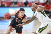 Texas Tech's Kevin McCuller (15) attempts to drive the ball around Baylor's Mark Vital (11) during the first half of an NCAA college basketball game in Lubbock, Texas, Saturday, Jan. 16, 2021. (AP Photo/Justin Rex)