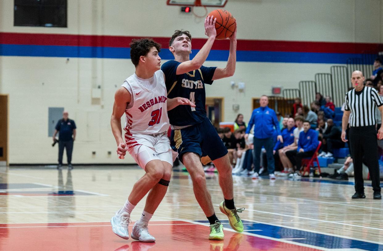 Council Rock South's Mike Burns (4) drives to the basket as Neshaminy's Logan Gale (31) defends.