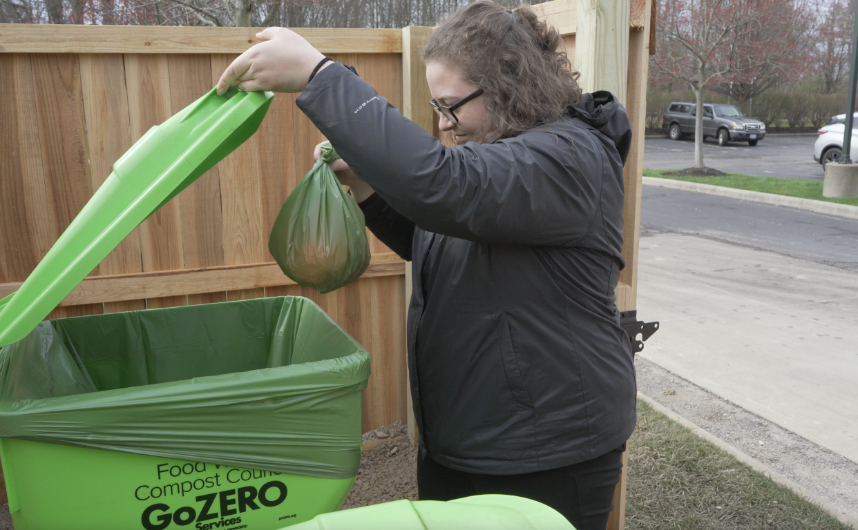 Anna van der Zwaag, planner for the city of New Albany and staff support for the Sustainability Advisory Board, drops recyclable food waste, collected in a compost-safe bag, into one of the city-owned bins. Recent data suggests residents are adapting to the free, citywide program.