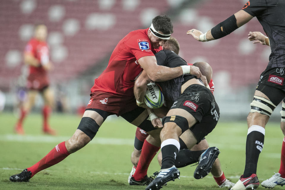 Luke Thompson of the Sunwolves tackles Daniel du Preez of the Shark during the Super Rugby match between the Sunwolves and the Sharks at Singapore National Stadium, in Singapore, Saturday, Feb. 16, 2019. (AP Photo/Danial Hakim)