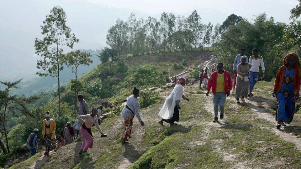 People climbing a steep path in Gofa at the site of two landslides