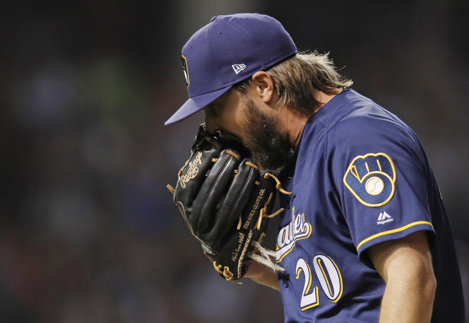 Milwaukee Brewers' Wade Miley yells into his glove as he walks off the field at the end of the first inning of a baseball game Monday, Sept. 10, 2018, in Chicago. (AP Photo/Jim Young)