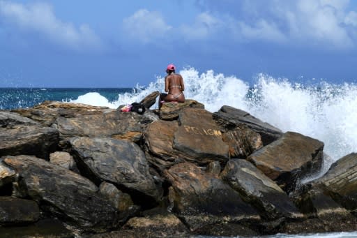 A woman sunbathes on the rocks at Camurichico beach in La Guaira, Vargas state, Venezuela