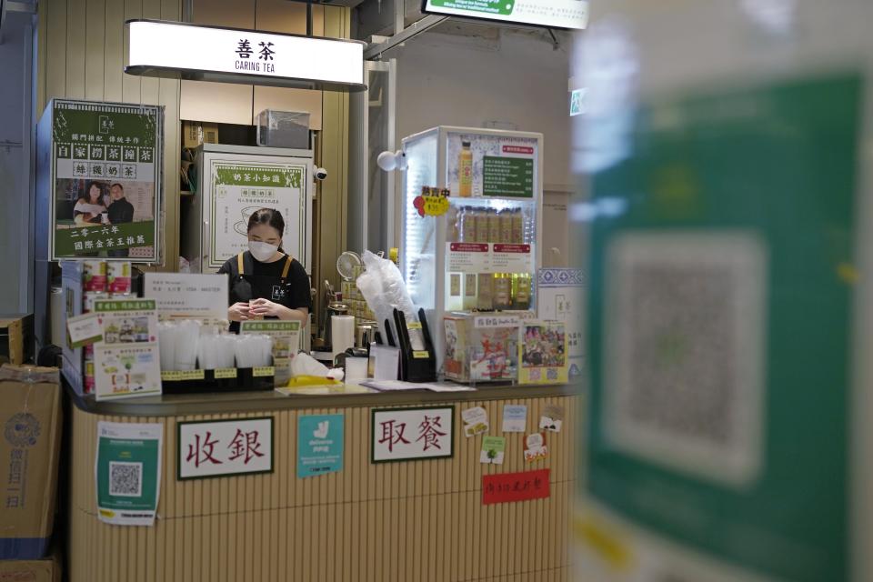 The government's contact tracing QR code for the "LeaveHomeSafe" COVID-19 mobile app are displayed at a store in Hong Kong, Tuesday, July 12, 2022. Hong Kong's leader John Lee on Tuesday defended plans to introduce a new virus "health code" that would use mobile phones to classify people as "red" or "yellow" and limit their movement. (AP Photo/Kin Cheung)