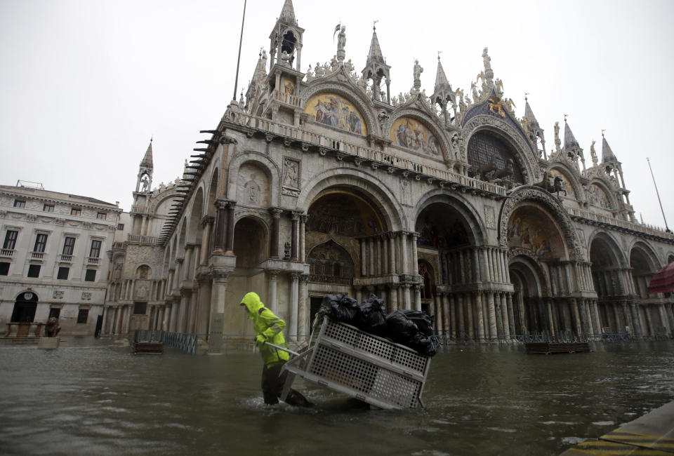 A rubbish collector carries bags in St Mark's Square (AP)