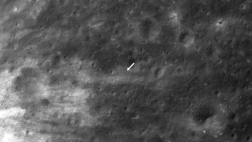 A white arrow points to the location of the SLIM lander on the lunar surface, as imaged by the Lunar Reconnaissance Orbiter. - NASA/Goddard/Arizona State University